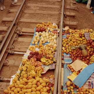 Blankets lie between train tracks displaying heaps of Peruvian produce including bananas, potatoes and onions.