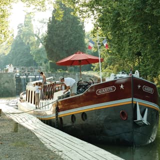 The Alouette is moored in front of a picturesque lock in the dappled shade of the plane trees that line the Canal du Midi.