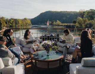 Three women and two men relax on the upper deck of Coquelicot, reading, chatting, sipping coffee and drinking in the views.