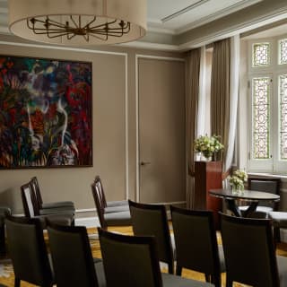 Guests' chairs face a registry table flanked by wood plinths with floral displays in a wedding detail in the Oscar room.