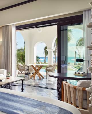 View from a king-size bed across luxurious hotel room and patio area