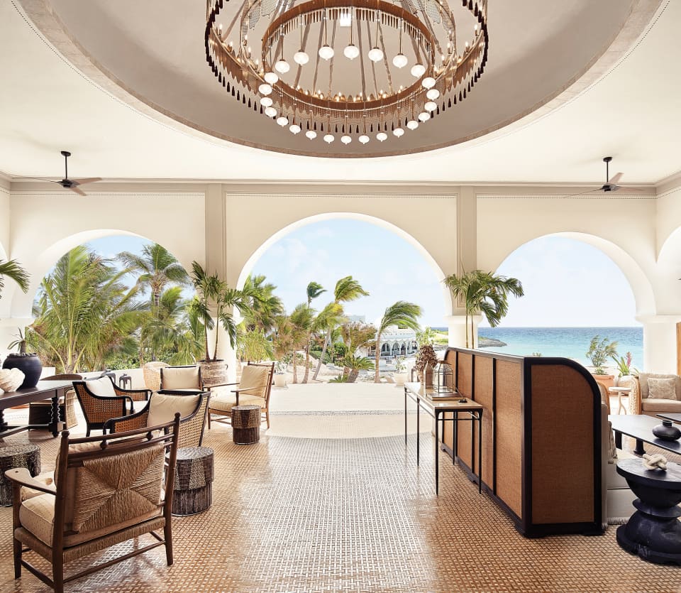 Hotel guest lobby area with archways and modern circular chandelier