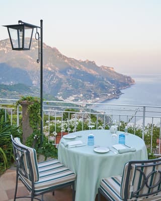 An intimate dining table, covered with an apple green tablecloth, throws open horizon wide views of the Tyrrhenian Sea