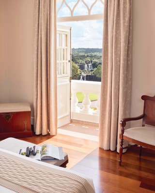 Sunlight spilling through balcony doors onto a polished wooden hotel room floor