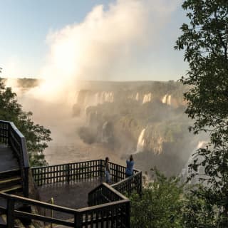 A couple photographing the Iguassu Falls at sunrise