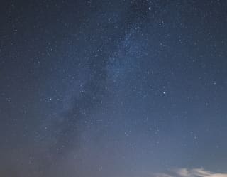 The Milky Way snakes across the heavens, a cloudy ripple in the darkness marking our galaxy among an ocean of stars