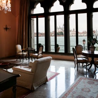 The domes of St Mark’s Basilica are visible across the Canale di Guidecca through full height Moorish windows