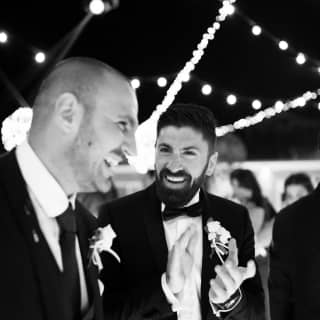 A smiling couple in black tie dress at a party