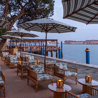 View from Il Bacaro Dior's Toile de Jouy seating, with evening candles, towards Cip's Club and The Giudecca Canal.