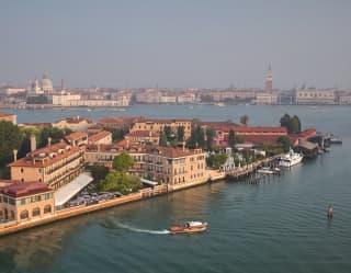 The Hotel Cipriani’s launch leaves a wake as it pulls away from the private dock. Behind, the iconic pink walls stand majestic