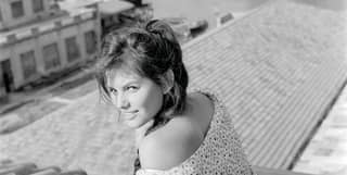 A black and white image of a young woman reclining on terracotta rooftiles, with the canal far below