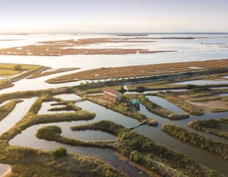 An aerial view of Lio Piccolo with its letter-like shapes of fishing zones bordered by sandbars and grassy levees