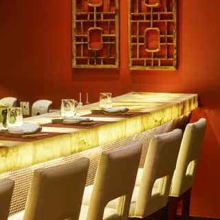 Contemporary underlit banquet table surrounded by white leather chairs
