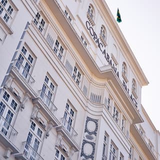 Low angle shot of the hotel front with 'Copacabana Palace' inscription and Brazilian flag