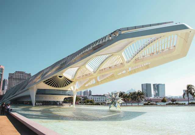 A sci-fi-like awning extends from the Museum of Tomorrow over a concourse with a mirrored star-shaped sculpture.