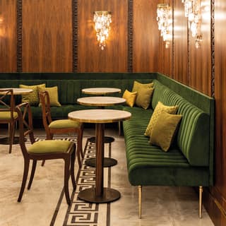 Droplets of glass hang from the wall chandeliers. Carved roses in the wood panels and marble floors add to the feel of luxury