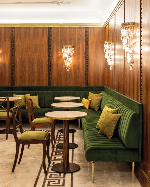 Droplets of glass hang from the wall chandeliers. Carved roses in the wood panels and marble floors add to the feel of luxury