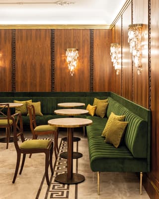 Droplets of glass hang from the wall chandeliers. Carved roses in the wood panels and marble floors add to the feel of luxury