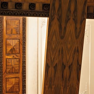The grain of polished wood panels creates sumptuous patterns. Narrow brass railings add art deco styling to curved balconies