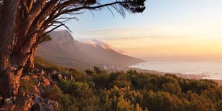 Table Mountain coated with clouds at sunrise that stretch to the sea