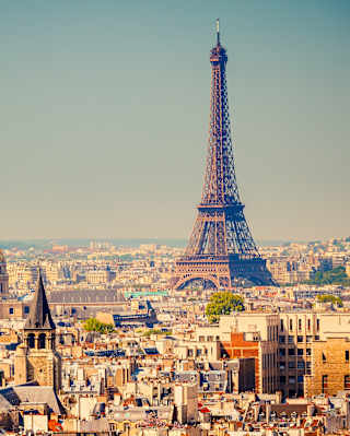The Eiffel Tower rising above Paris skyline into clear blue skies