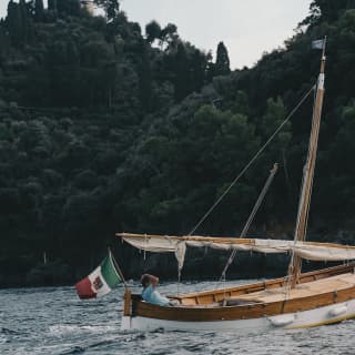Man in blue shirt relaxing on a traditional Italian gozzo boat