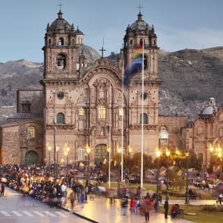 Cusco cathedral at sunset with mountains in the background