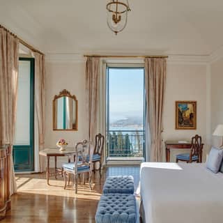 Double-height hotel room with powder blue accents and floor to ceiling windows