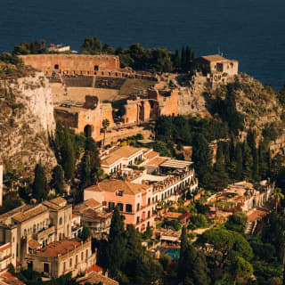 View east of the Ancient Theatre and below it Grand Hotel Timeo, settled into the warm-peach terracotta terraces of Taormina.