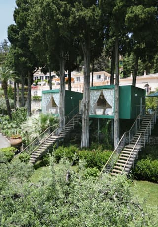 Two Dior treatment rooms peek out from the trees in the Garden of Dreams, high rise individual pods reminiscent of treehouses>