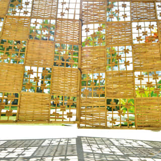 The Spa's wicker gate, made with a chequerboard of tight-woven panels and flowery grids, casts pretty shadows on the ground.