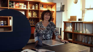 Patricia de la Torre stands at a table in her atelier where she creates the textured floral shapes that adorn the boat walls.