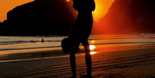 As the sun sets over Taormina's coast, Sam Youkilis captures a boy, silhouetted against the red sky, performing a handstand.