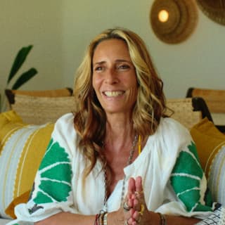 Maroma's interior decorator, Tara Bernerd, with blond hair and linen top smiles while photographed in a suite she designed.