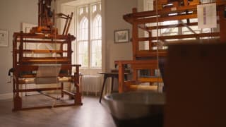 Two large wood looms loaded with wool bathe in natural light from large windows in the workshop of Araminta Birse-Stewart.
