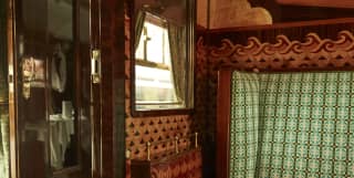 Walnut panelling encases an emerald-green patterned seat in the Cygnus carriage, re-designed by film director Wes Anderson.