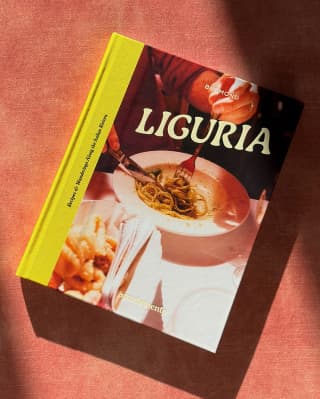 The cover of cookbook ‘Liguria: Recipes & Wanderings Along the Italian Riviera’ depicts a diner enjoying a bowl of spaghetti.