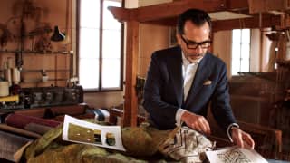 In a workshop with a large loom, Nicolò Favaretto of Rubelli examines silks created for the Venice Simplon-Orient-Express.