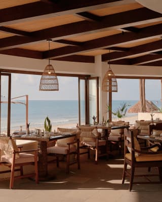 Window tables bathe in wide exterior sea-views and the interior elegance of Casa Mayor's calming, white and wicker décor.