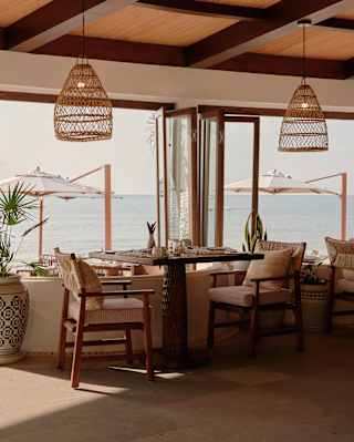 A window table makes the most of the cool interior with views onto the sunny sea-view terrace with cantilever parasols.