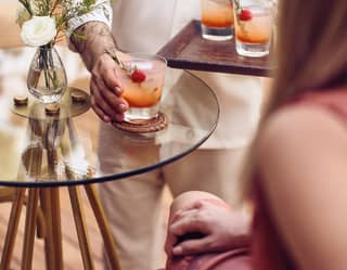 a staff is serving a cocktail to a lady