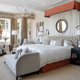 Spacious hotel room with double-height ceiling and crystal chandelier