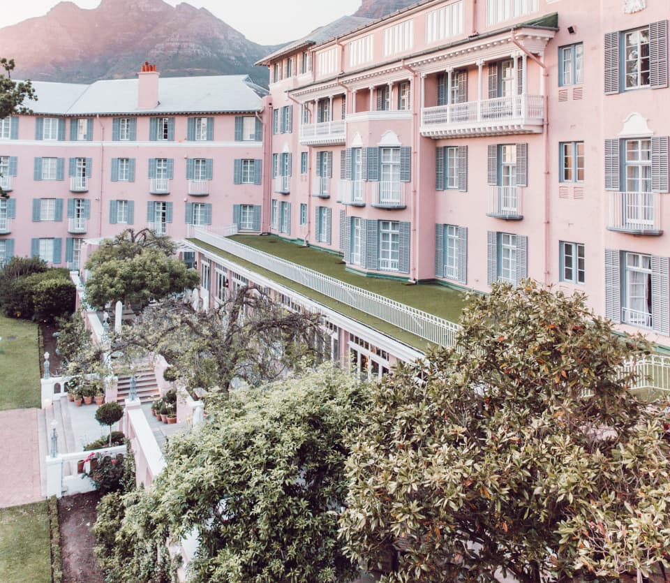Glamorous colonial style hotel with pink facade beside Table Mountain