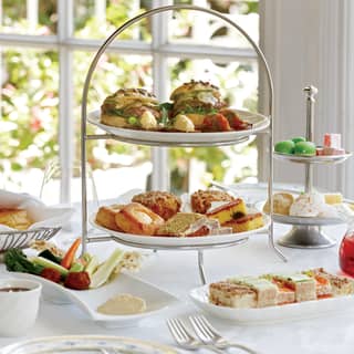 Linen-coated table with a cake stand laden with cakes and treats