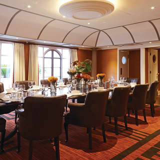 Meeting room with comfy armchair seats around a polished wood table