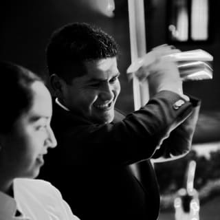 Bar staff mix cocktails for guests at the discreetly lit lobby bar in the Monasterio Hotel in Cusco