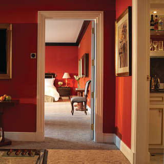 The grey patterned carpet leads from the lounge area of a terrace suite into the spacious bedroom beyond