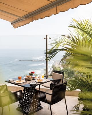 Modern ironwork table on a balcony overlooking the ocean around Lima