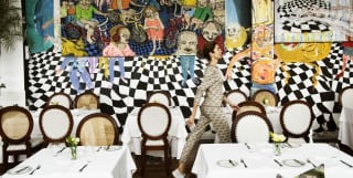 A woman walking between the tables of Tragaluz Restaurant