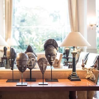 Guest lobby side-table with lamps and Peruvian mask statuettes on top